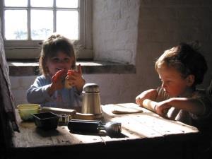 Two children baking bread at Bircham Windmill.