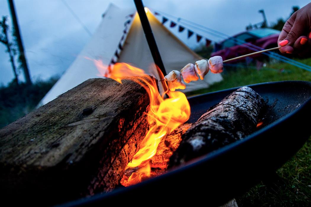 gather around a campfire to roast marshmallows with your loved ones while glamping here with us by the beach
