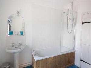 A family bathroom with bath and over head shower