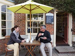 A couple enjoying a cup of tea near the village green at Castle Acre Village in West Norfolk.
