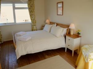 The master bedroom of the self-catering property in Brancaster Staithe. The bed is dressed with white bed covers and has two white towels sitting on i