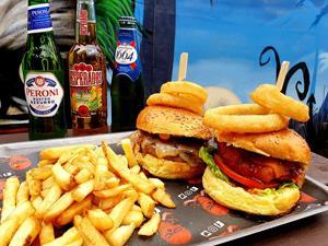 Delicious loaded platter of two burgers with onions rings, fries and selection of beers and lagers.