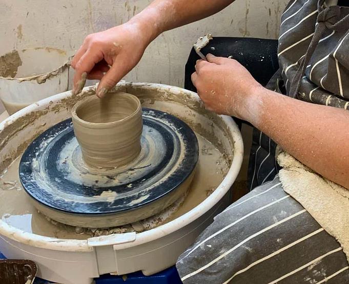 Showing a pottery class.