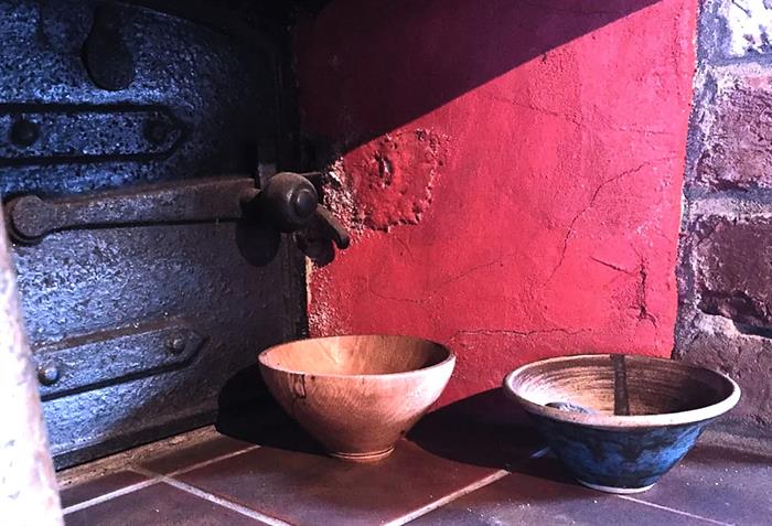 Showing wood and clay items next to a kiln.