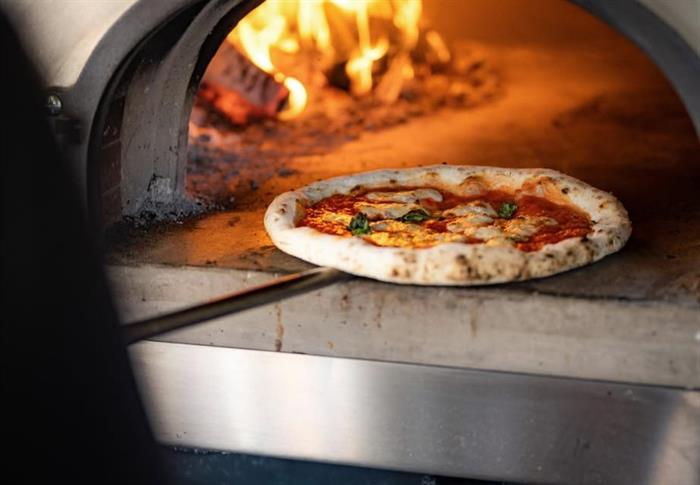 Image of pizza being pulled out of an oven.