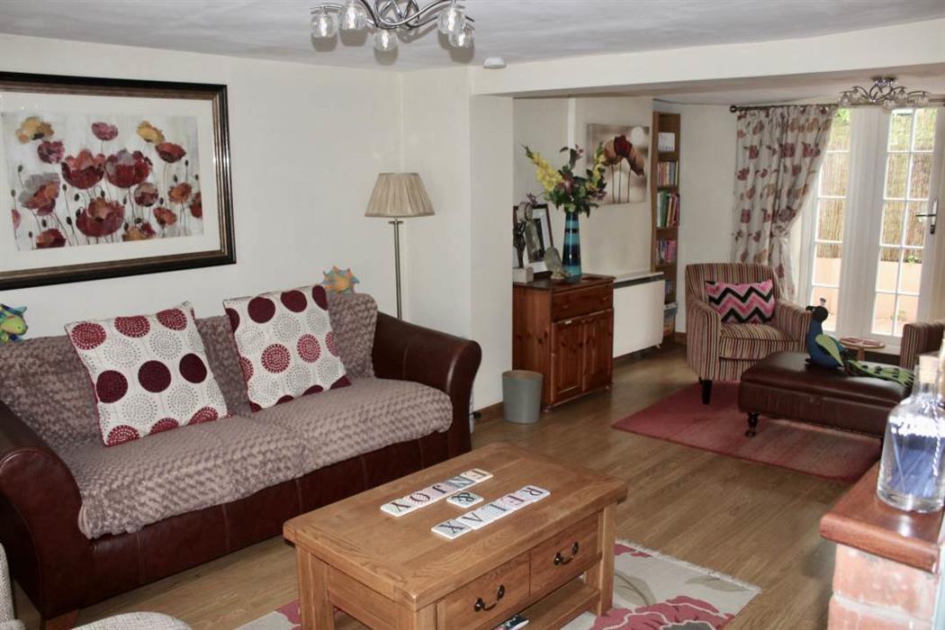 Living area with sofas, coffee tables and fireplace.