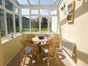 Sunny conservatory with dining table overlooking the garden.