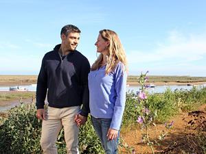 A couple walking along the coastal path at Burnham Overy Staithe.