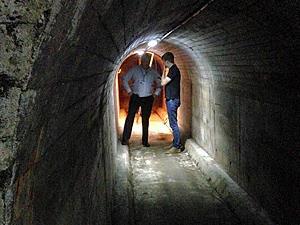 Two people standing in King's Lynn Air Raid Shelter underneath the Tuesday Market Place.
