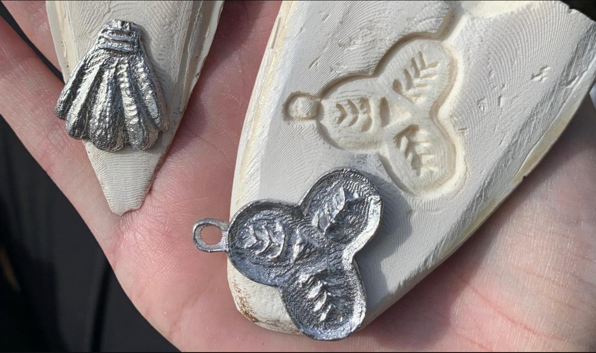 Image of pewter pilgrim badges next to a plaster mould.