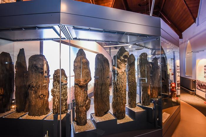 The Bronze Age timbers from 'Seahenge' on display in glass cases at Lynn Museum. A projected image of the beach where it was found can be seen in the