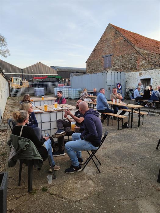 People sitting outside, drinking cider.