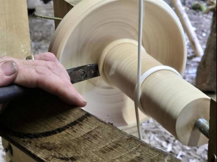 Closeup of a wooden bowl being turned on a pole lathe.