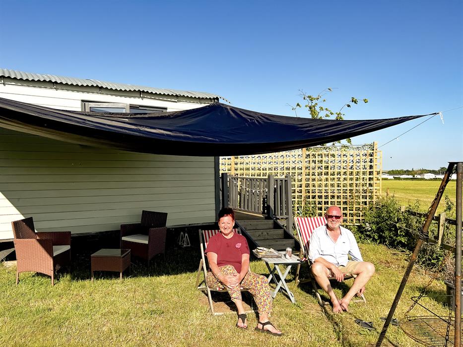 couple enjoying the sunshine in our glamping shepherds huts