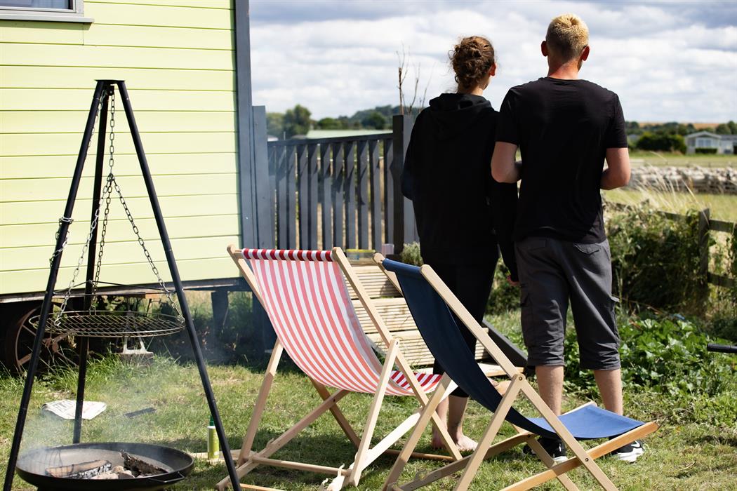 couple enjoying the view from their glamping shepherds hut
