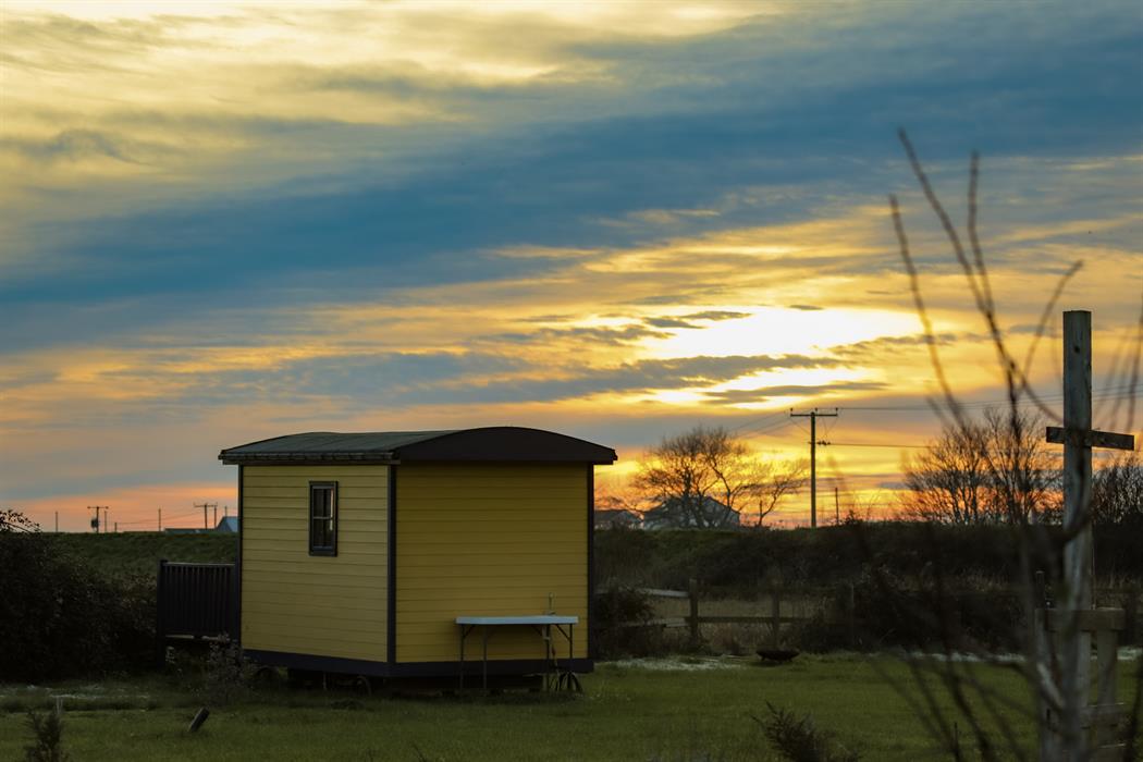 an autumn sunset over our glamping shepherds huts